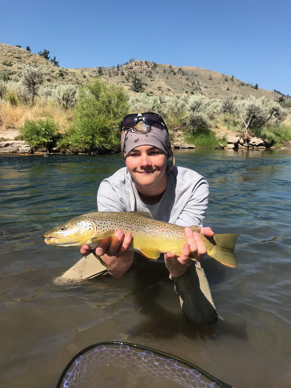 Person in a river holding fish